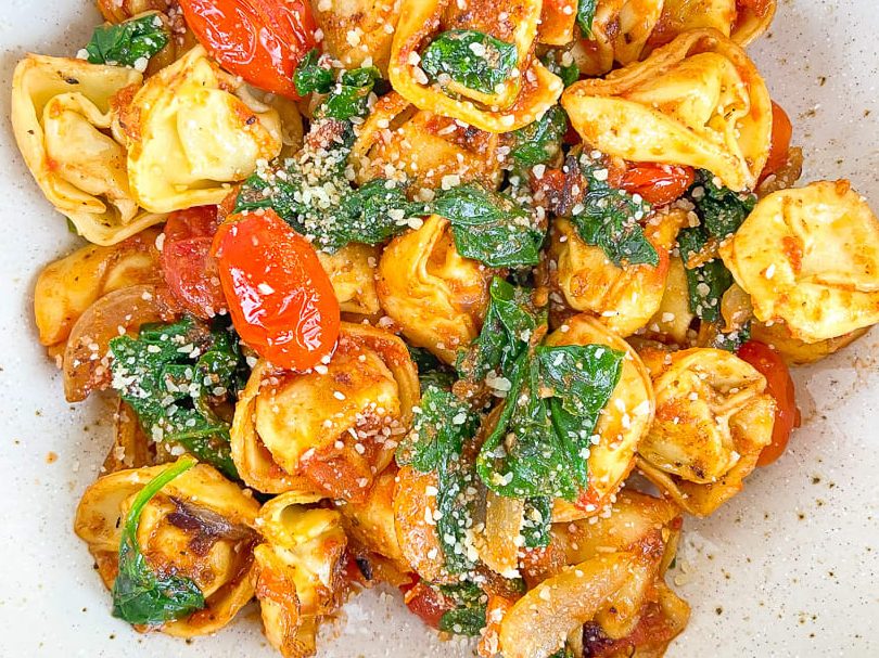 Tortellini de pollo con tomate y espinacas