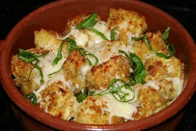 Corazones de alcachofa empanizados en salsa de mantequilla con ajo y cubiertos con...